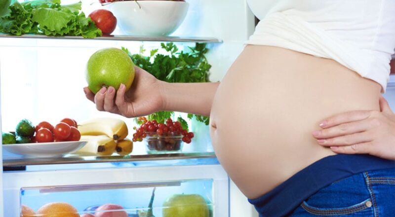 Grávida tomando ácido fólico para saúde do bebê