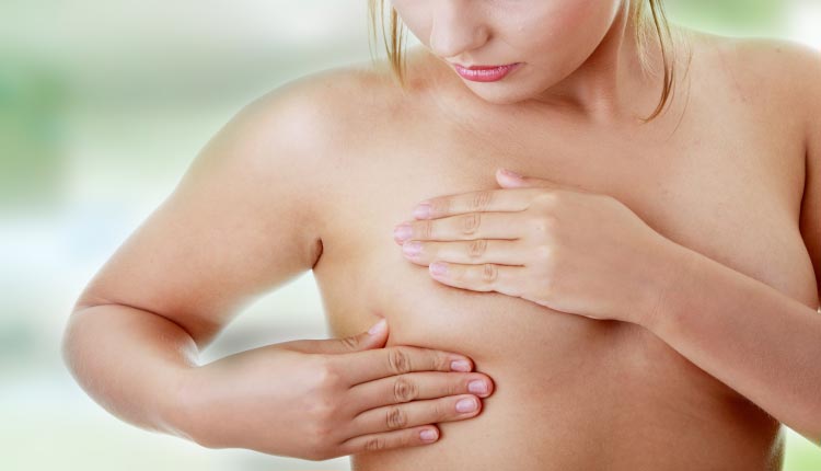 Mulher realizando autoexame das mamas