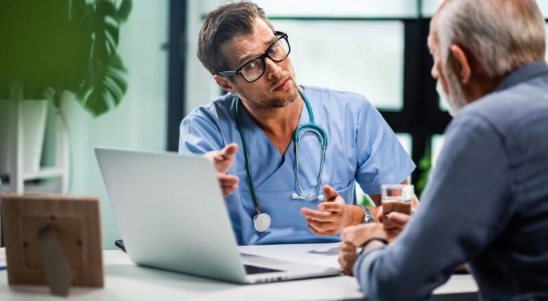 Médico conversando com paciente em ambiente clínico, demonstrando empatia e atenção.