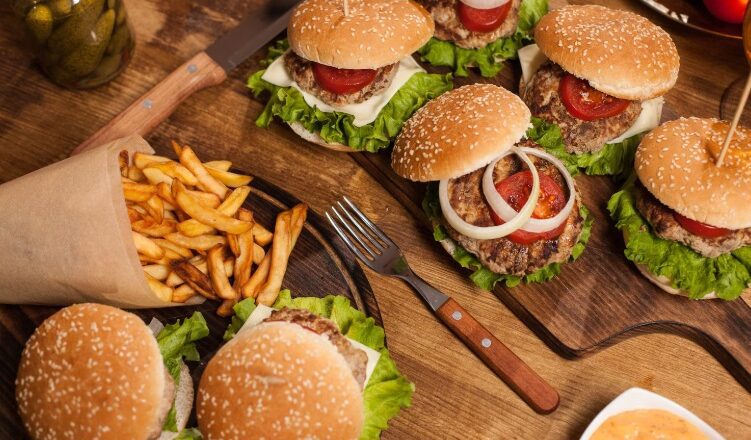 Um prato de fast food com hambúrguer e batatas fritas, simbolizando o impacto negativo da alimentação na saúde cognitiva.