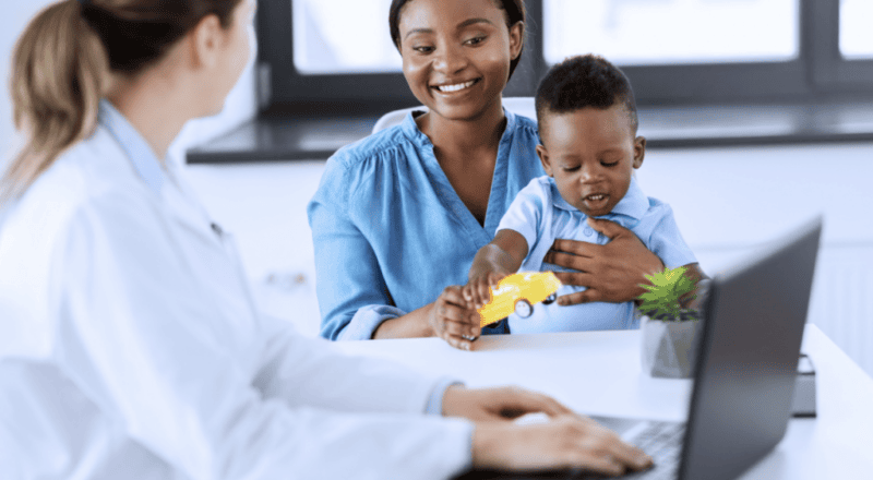 Médico cumprimentando uma criança durante uma consulta médica